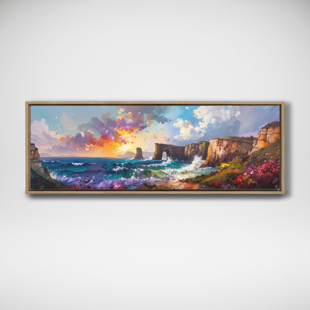 A framed panoramic landscape painting of a dramatic coastal scene with cliffs, ocean waves, and a colorful sunset sky, displayed on a light gray wall.